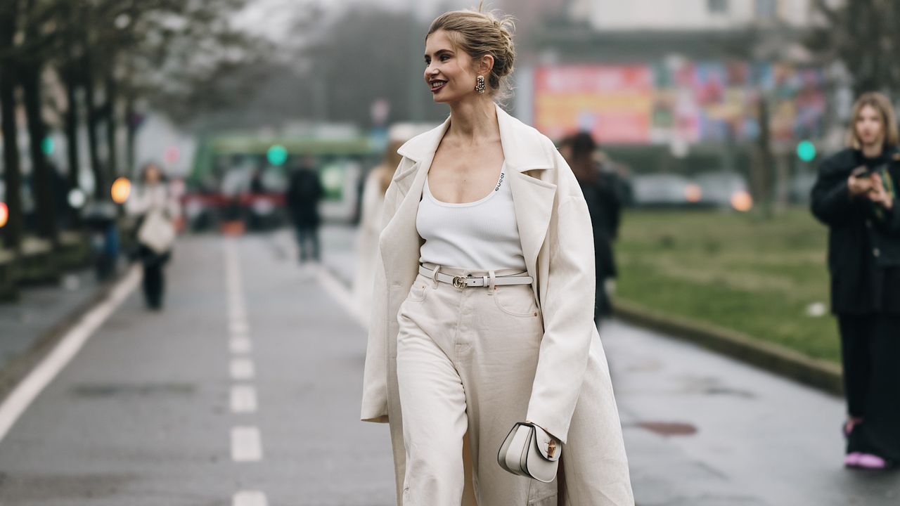 a milan fashion week fall winter 2025 attendee wearing white tank top beige coat and beige pants 