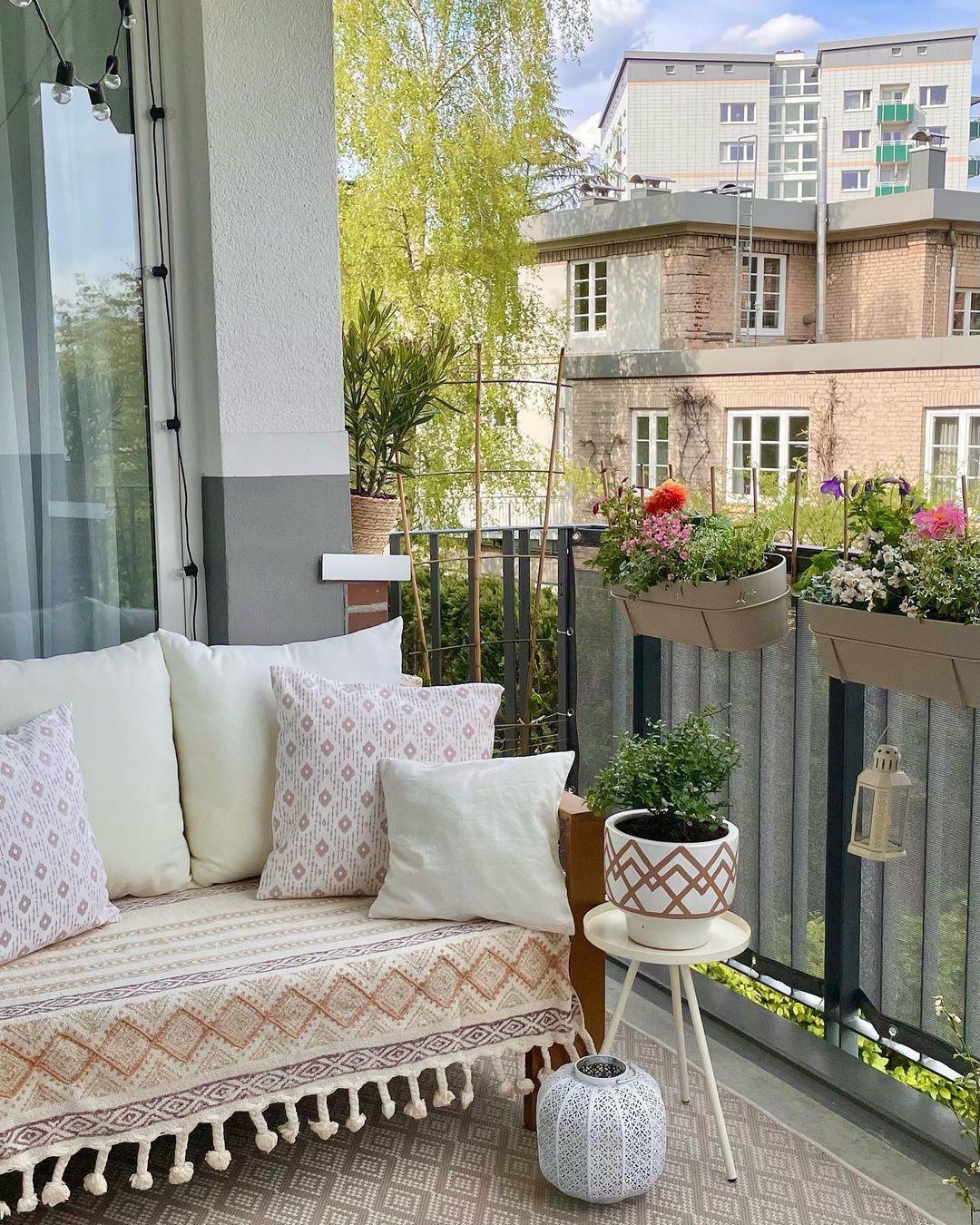 Balkon dengan sofa putih dan bantal