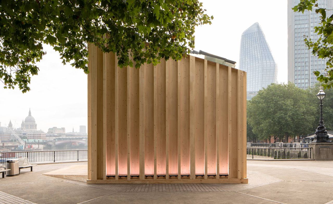 The exterior of the Cube by Velux. A wooden structure, that&#039;s higher on one end. In the background, we see the rest of London.