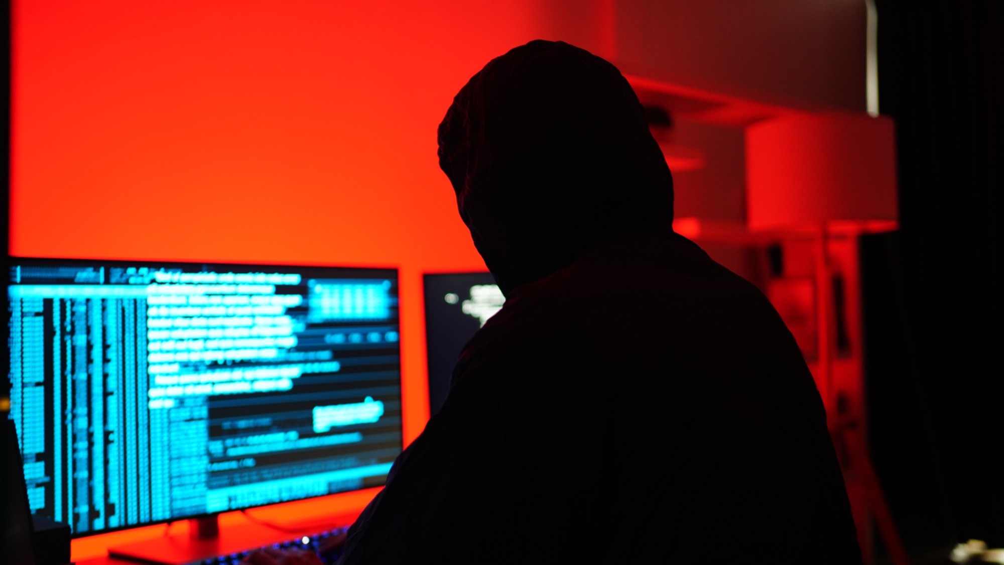 A stock photo of a hacker sitting at a computer. 
