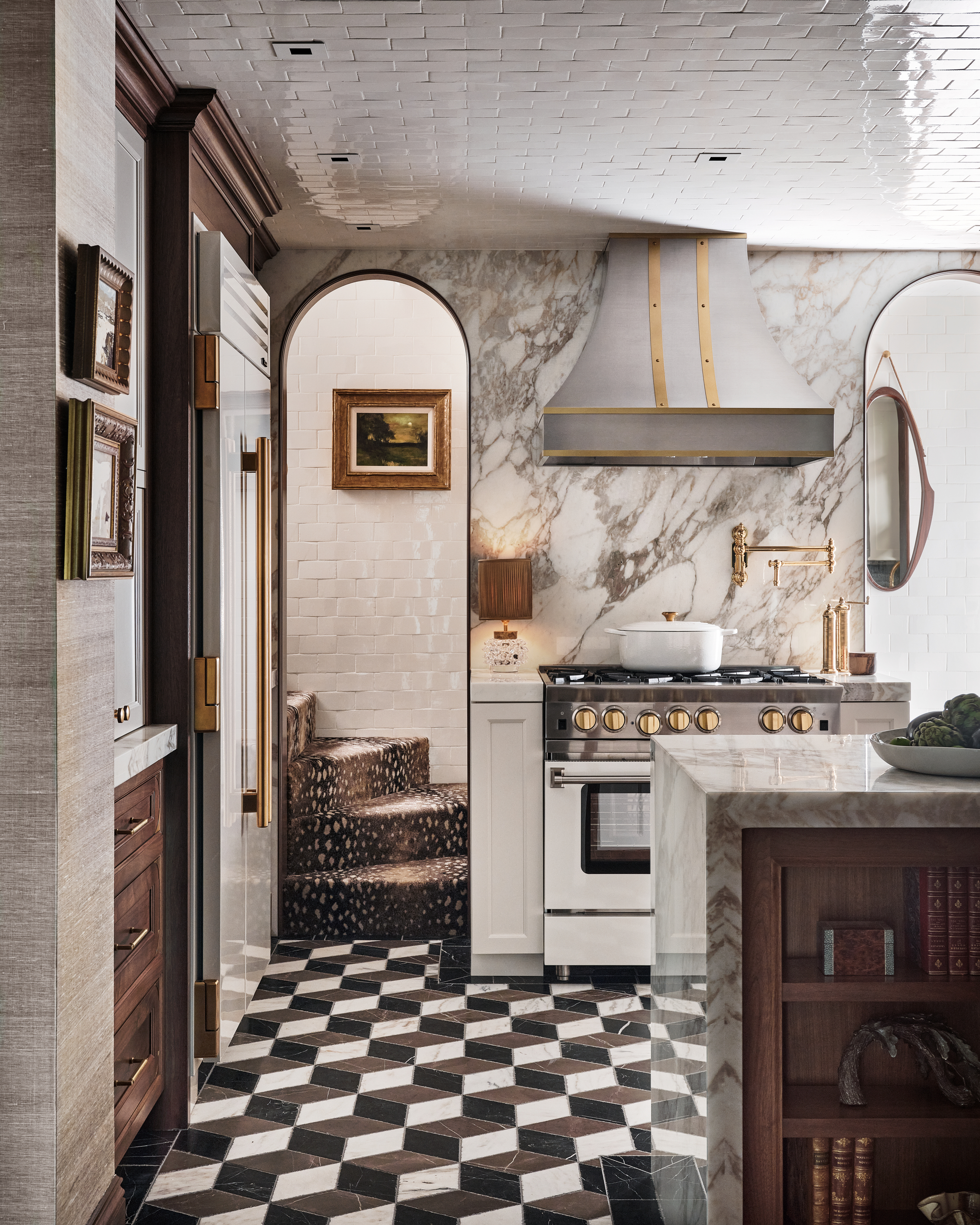 A kitchen with white ceiling tiles, and graphic floor tiles, along with a marble backsplash
