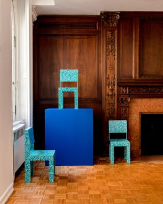 Blue chairs placed around large blue block