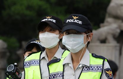 South Korean police officers protect themselves against MERS.