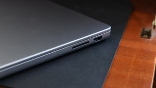 Close up of the SD card slot of an Apple MacBook Pro sitting on a desk