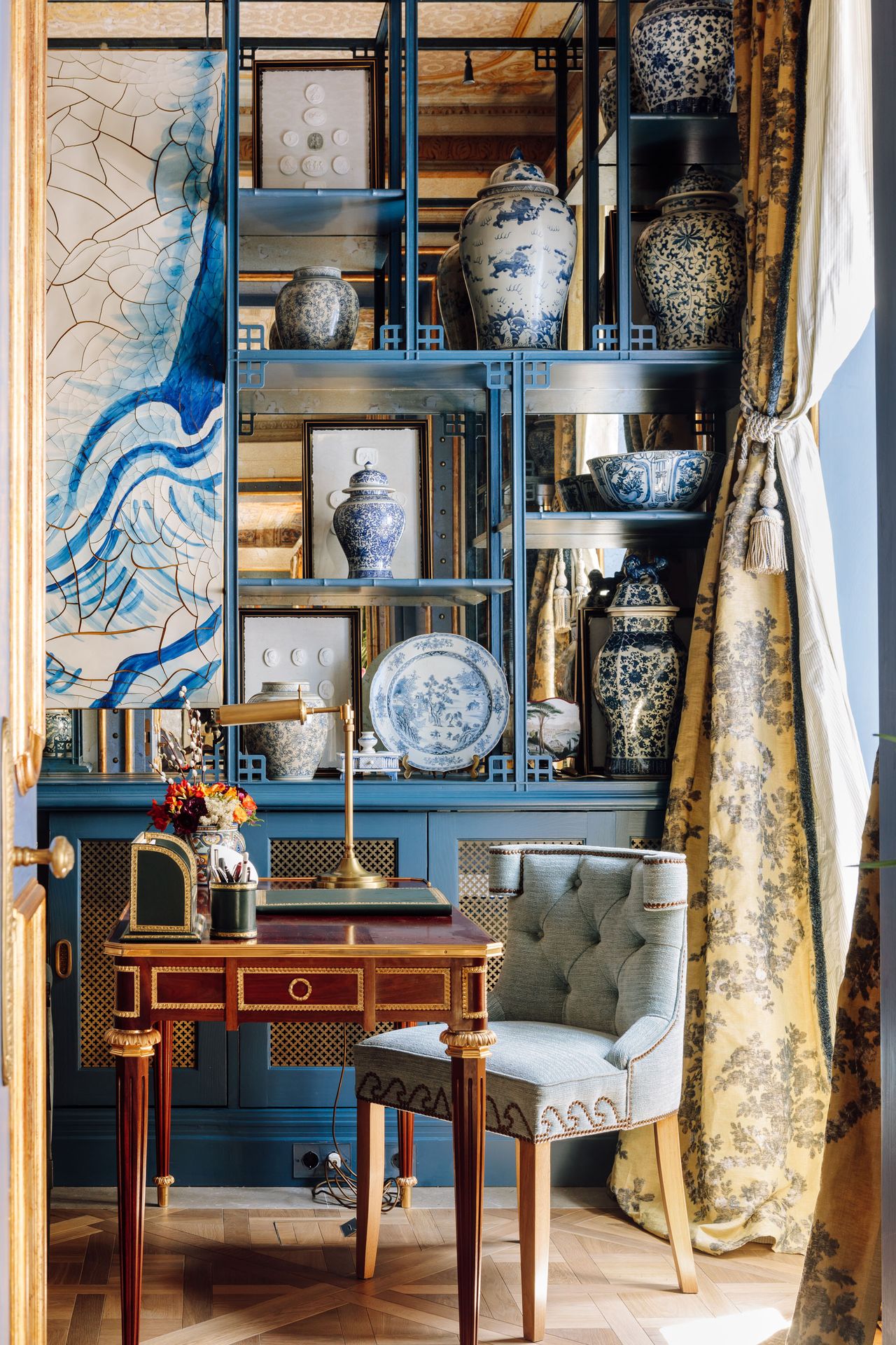 Blue shelves with pottery, and blue and white print