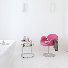 bathroom with white walls and pink chair