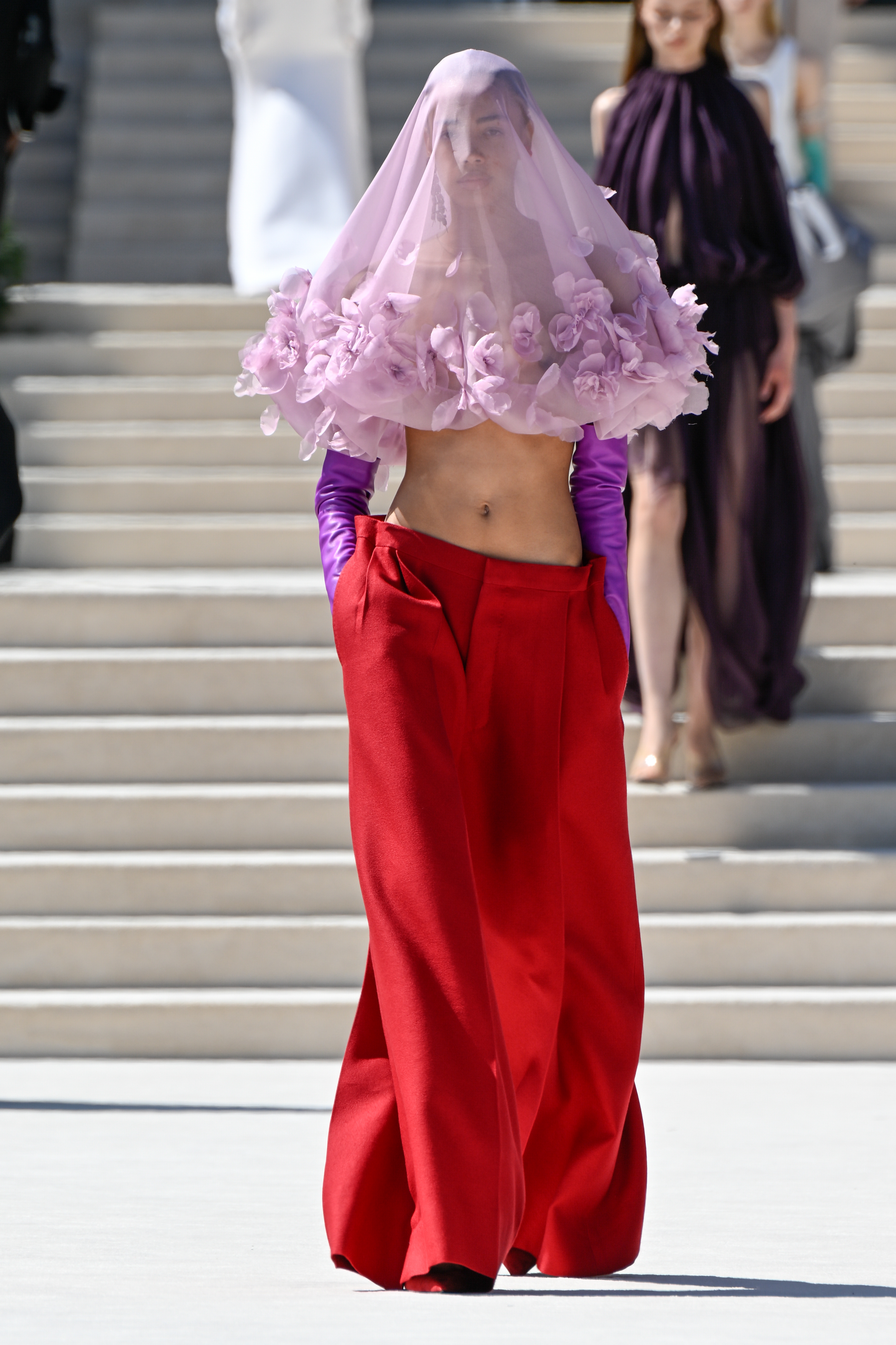 A model in a red-and-purple color combination on the Balenciaga Fall 2026 couture runway.