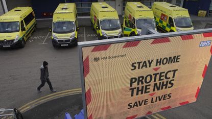 A man passes ambulances lined up outside the Royal Liverpool University Hospital.