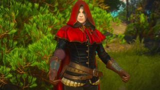 A woman in a red hood against vibrant green plant life