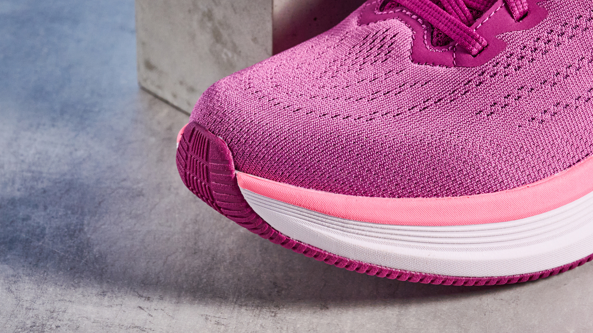 the skechers go run elevate 2.0 running shoes in the women's style, in fuchsia pink, photographed against a blue background