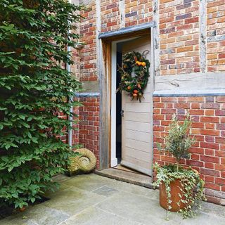 house exterior with brick wall and potted trees