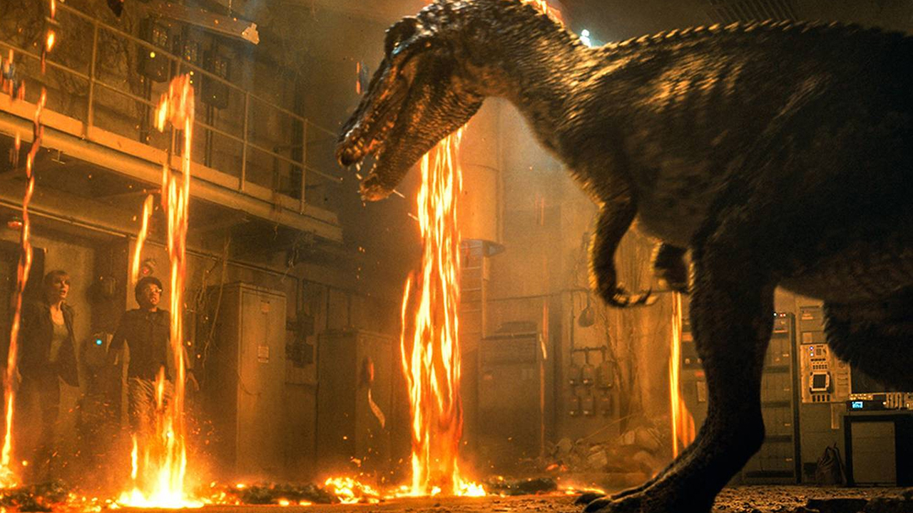 A frame from the movie Jurassic World: Fallen Kingdom.  Here we see a man and a woman confronting Baryonyx.  Around them, the lab they are in is collapsing, streams of lava flying through the air.