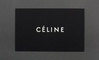 Front view of ﻿Céline's black and white invitation pictured against a grey background