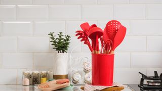 Red silicone cooking utensils in red container