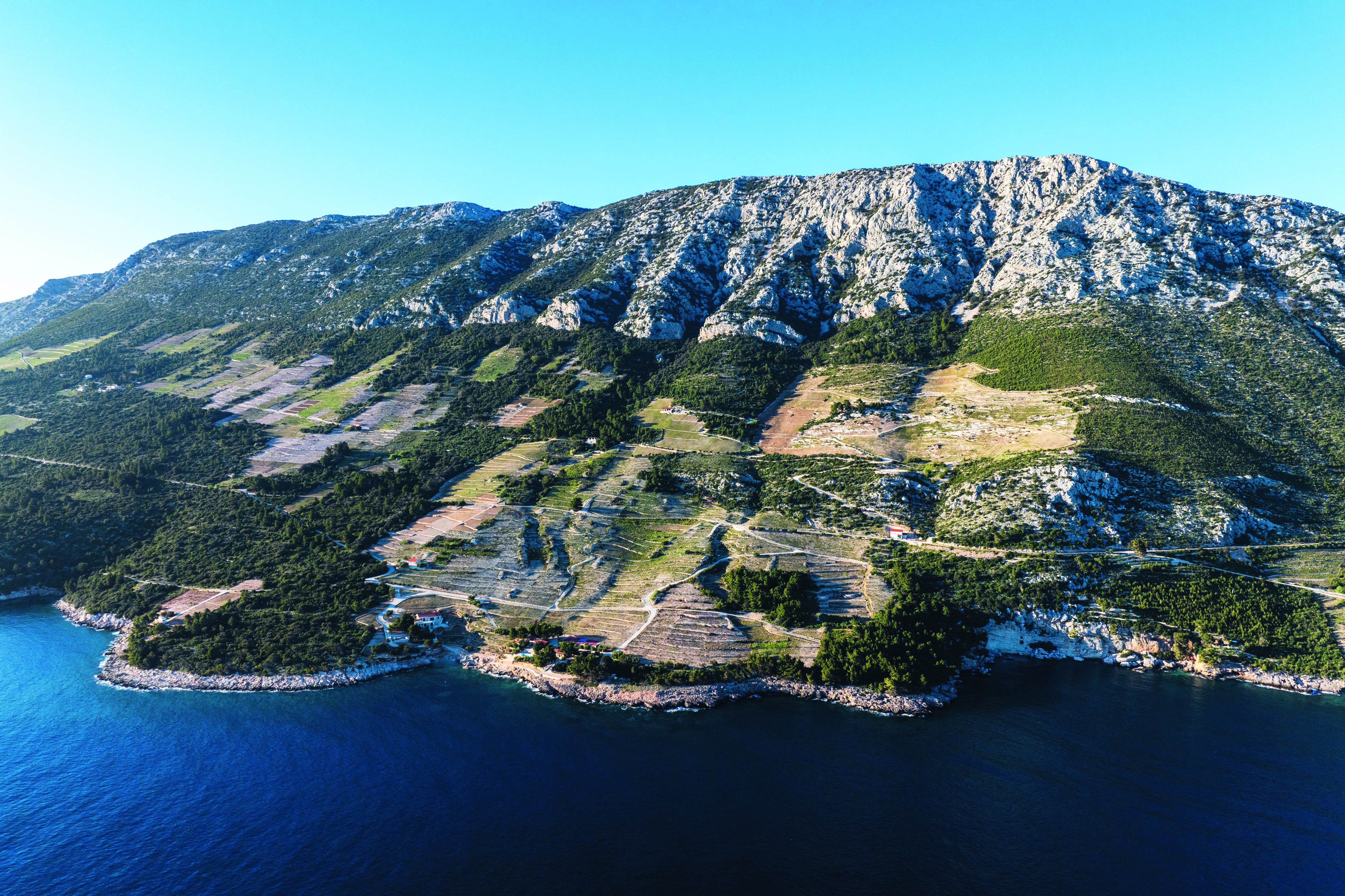 Pelje&amp;scaron;ac peninsula: view from the air of a coastline, with mountains in the background, greenery and rocky shorelines
