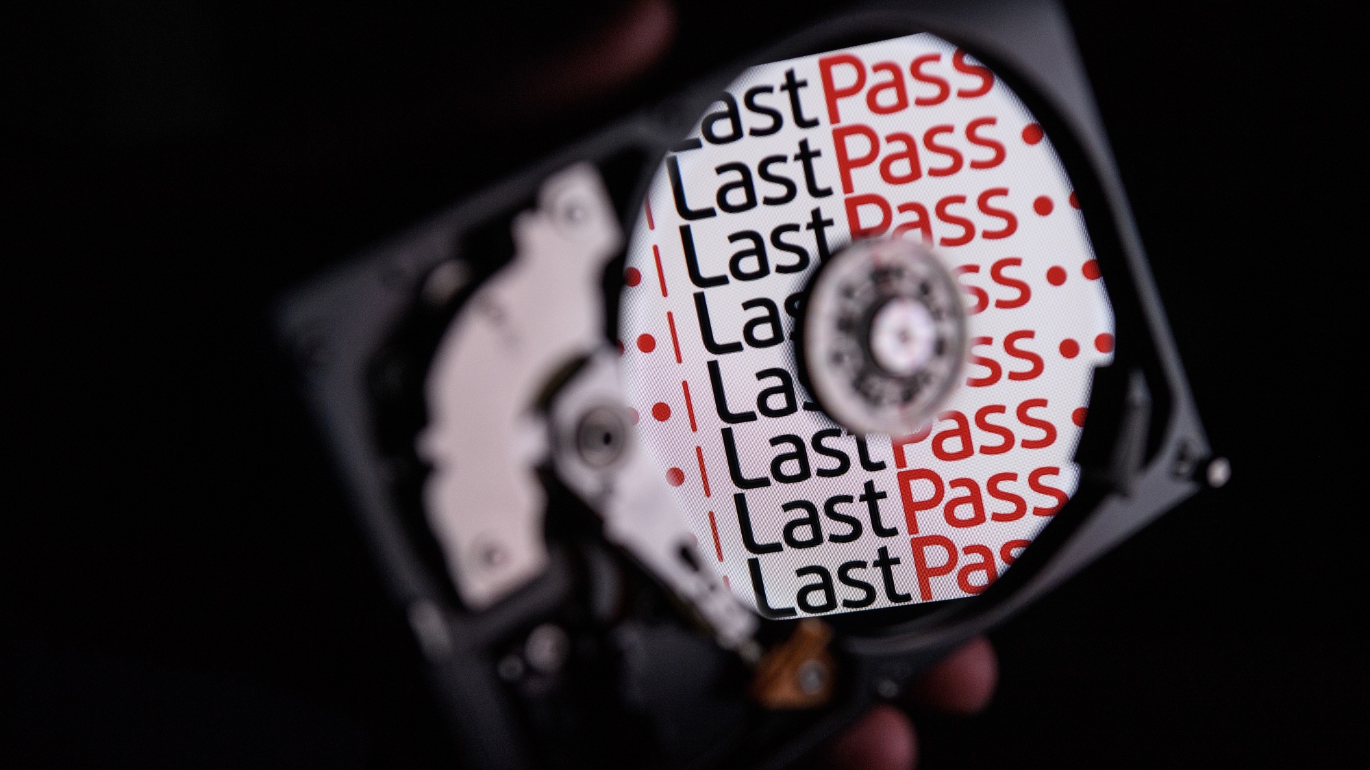 The logo for online password manager service "LastPass" is reflected on the internal discs of a hard drive.