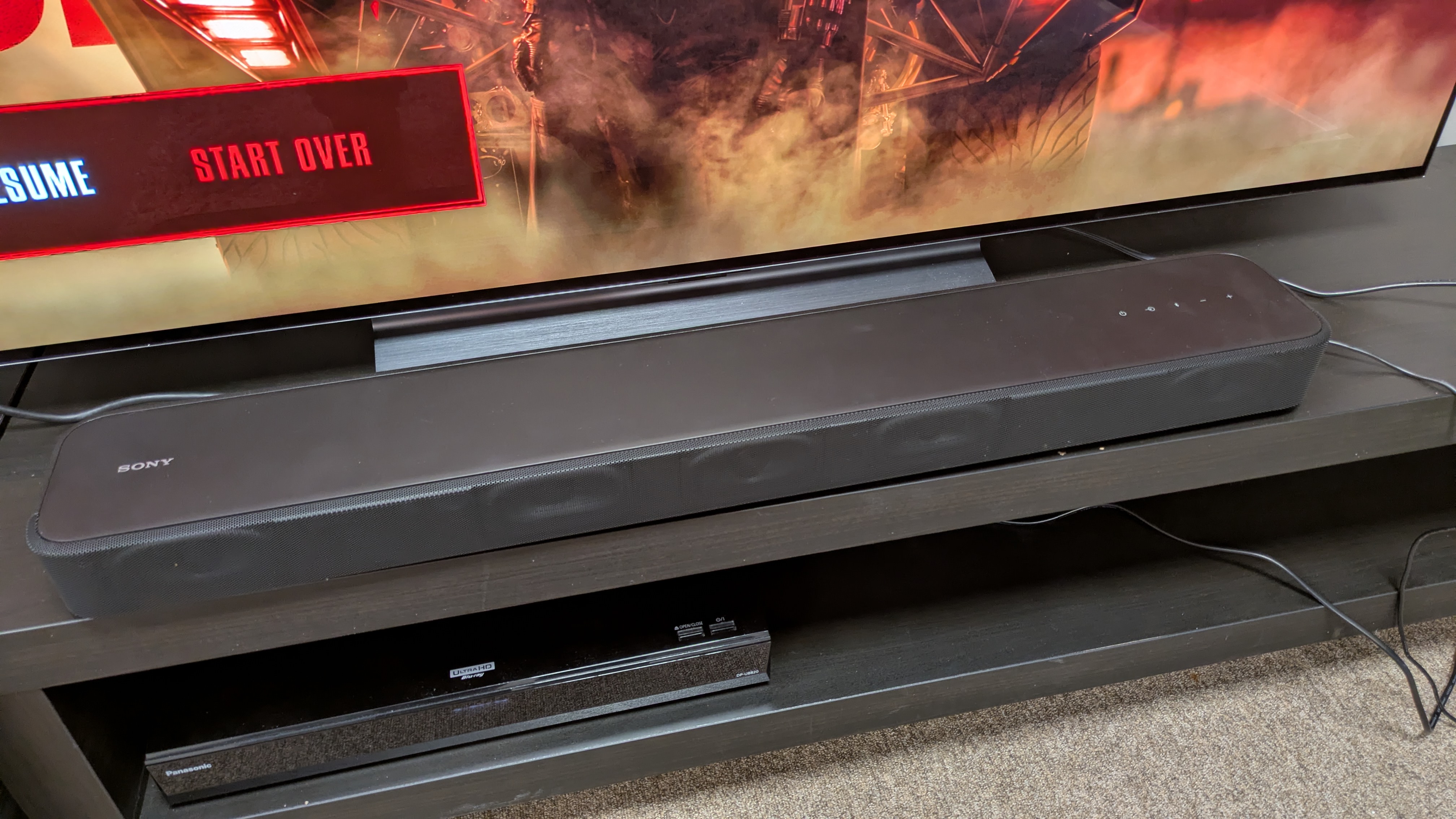 Sony HT-S2000 soundbar on dark wood stand 