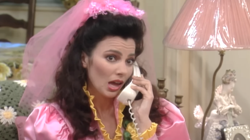 Fran Drescher in The Nanny on the phone while wearing a bright pink dress and veil 