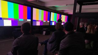 2022 Projector shootout with screens showing color bars test patterns