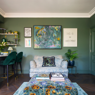 Living room with soft green walls and a blue patterened sofa.