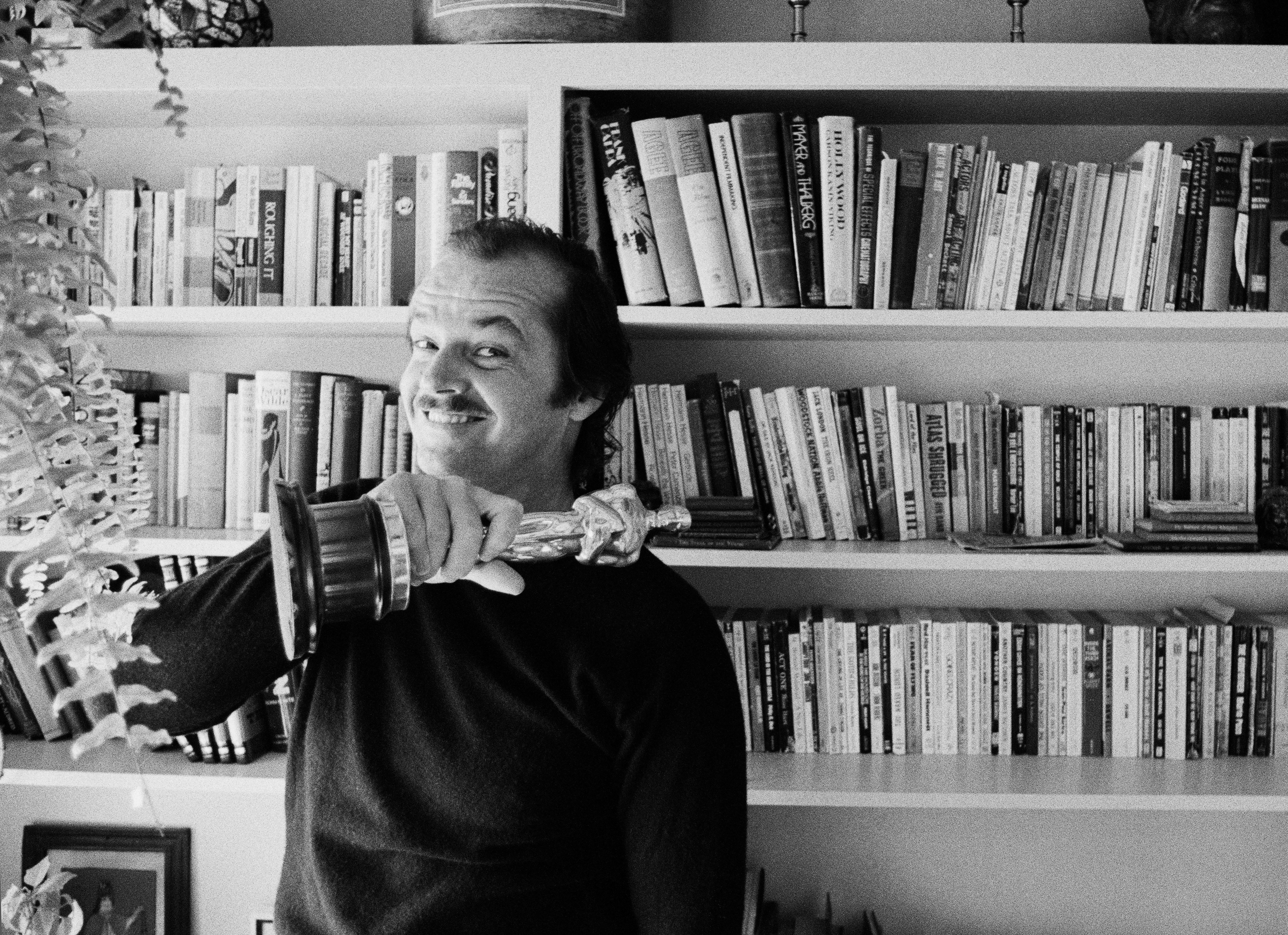 Jack Nicholson with an Oscar in front of bookshelves in black and white photographed by Douglas Kirkland