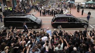 BIRMINGHAM, ENGLAND - JULY 30: Sharon Osbourne, Jack Osbourne, Kelly Osbourne and Aimee Osbourne view tributes to the late Ozzy Osbourne from fans at Black Sabbath Bench and Bridge as his funeral cortege travels through his home city of Birmingham on July 30, 2025 in Birmingham, England. The Black Sabbath frontman passed away on July 22nd at the age of 76. His death occurred just a little over two weeks after his final live performance at the 'Back to the Beginning' concert in his hometown of Birmingham. (Photo by Christopher Furlong/Getty Images)