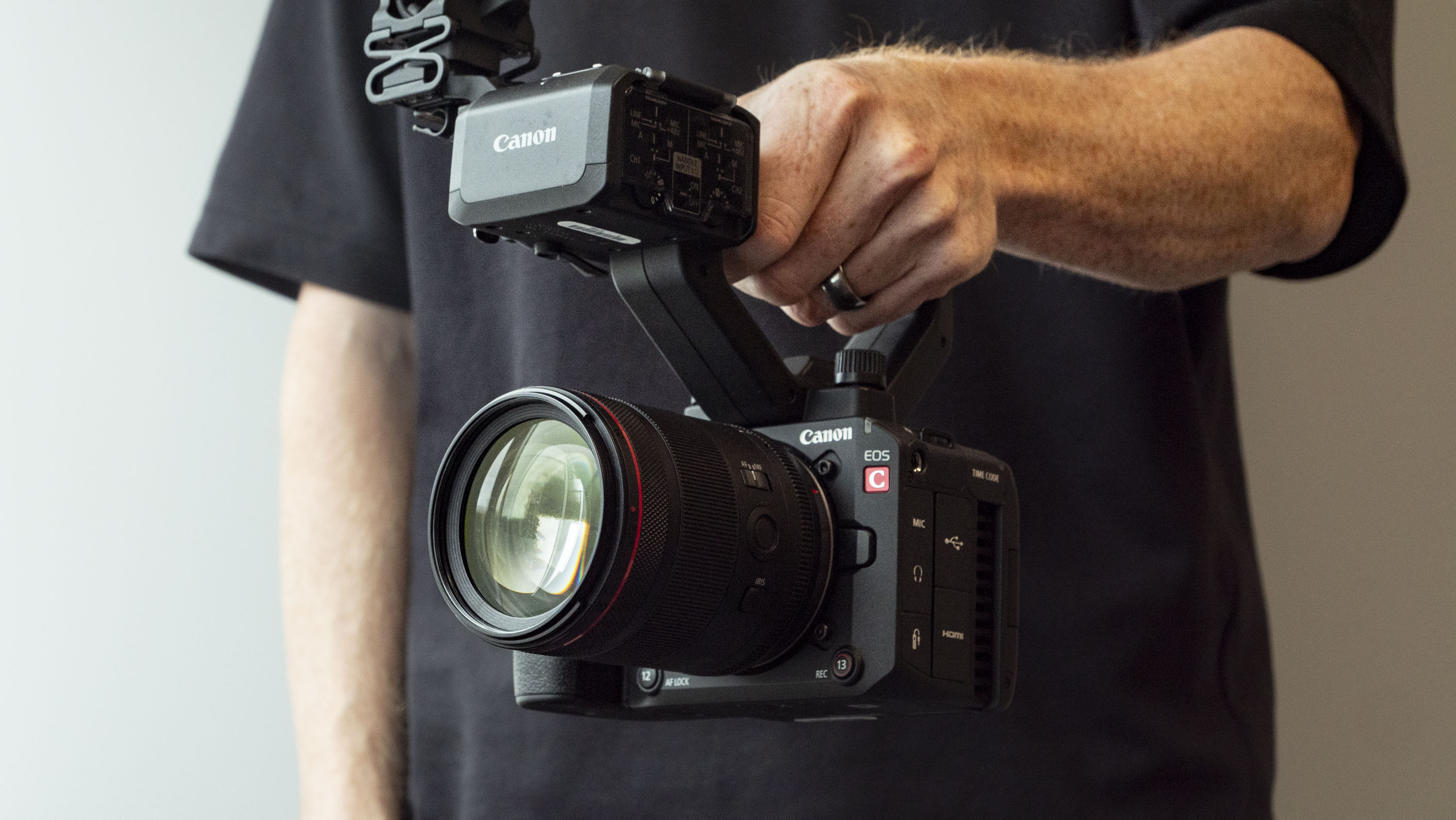 Canon EOS C50 with top handle, held by a filmmaker
