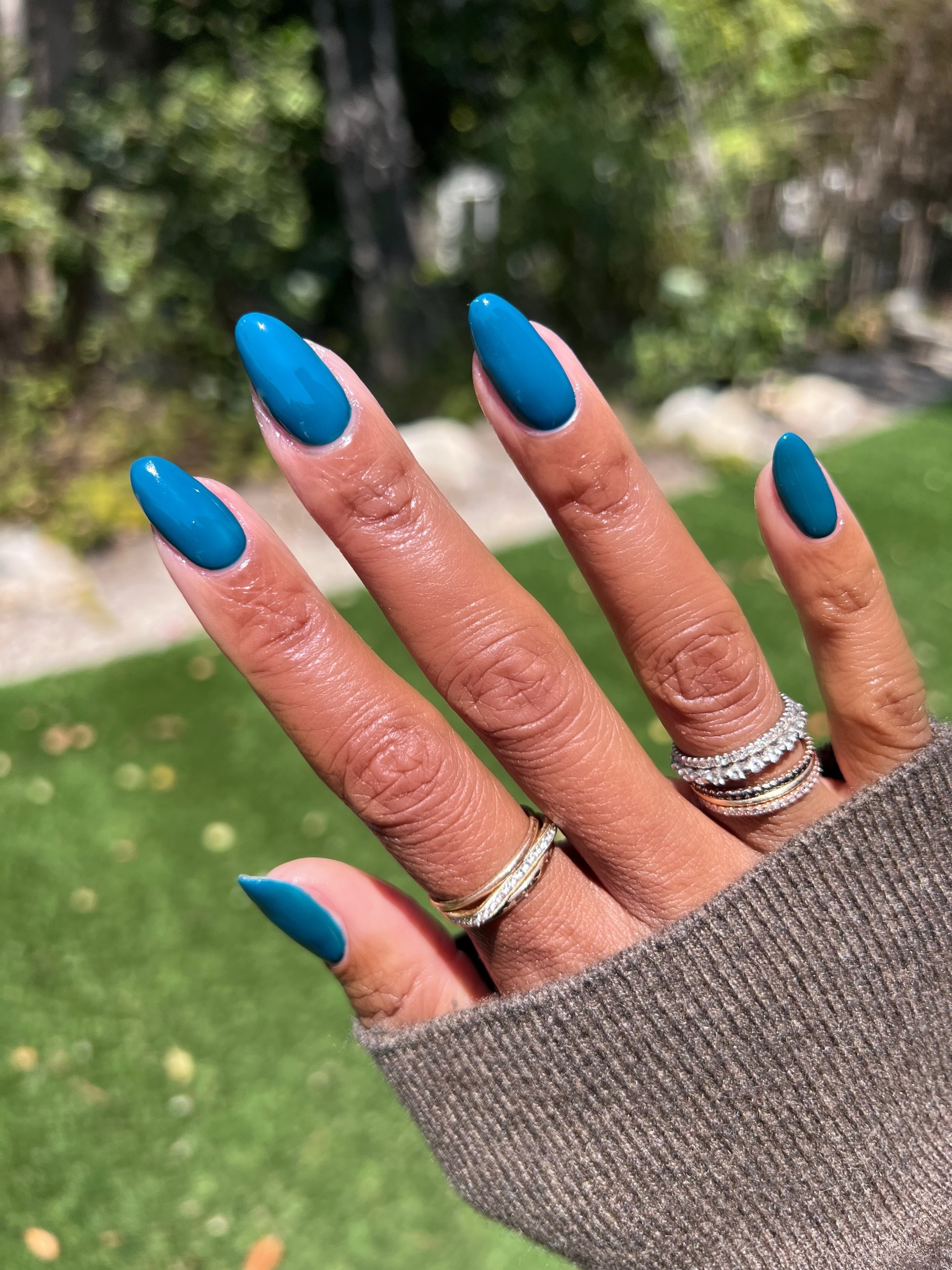A long, almond-shaped petrol blue manicure