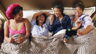 Tiffany Haddish, Jada Pinkett Smith, Regina Hall and Queen Latifah laughing in bed in Girls Trip