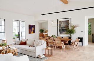 living room with white walls and white furniture with dining table visible and steel windows