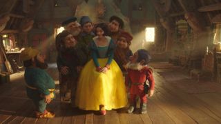 Rachel Zegler as Snow White surrounded by the seven dwarfs