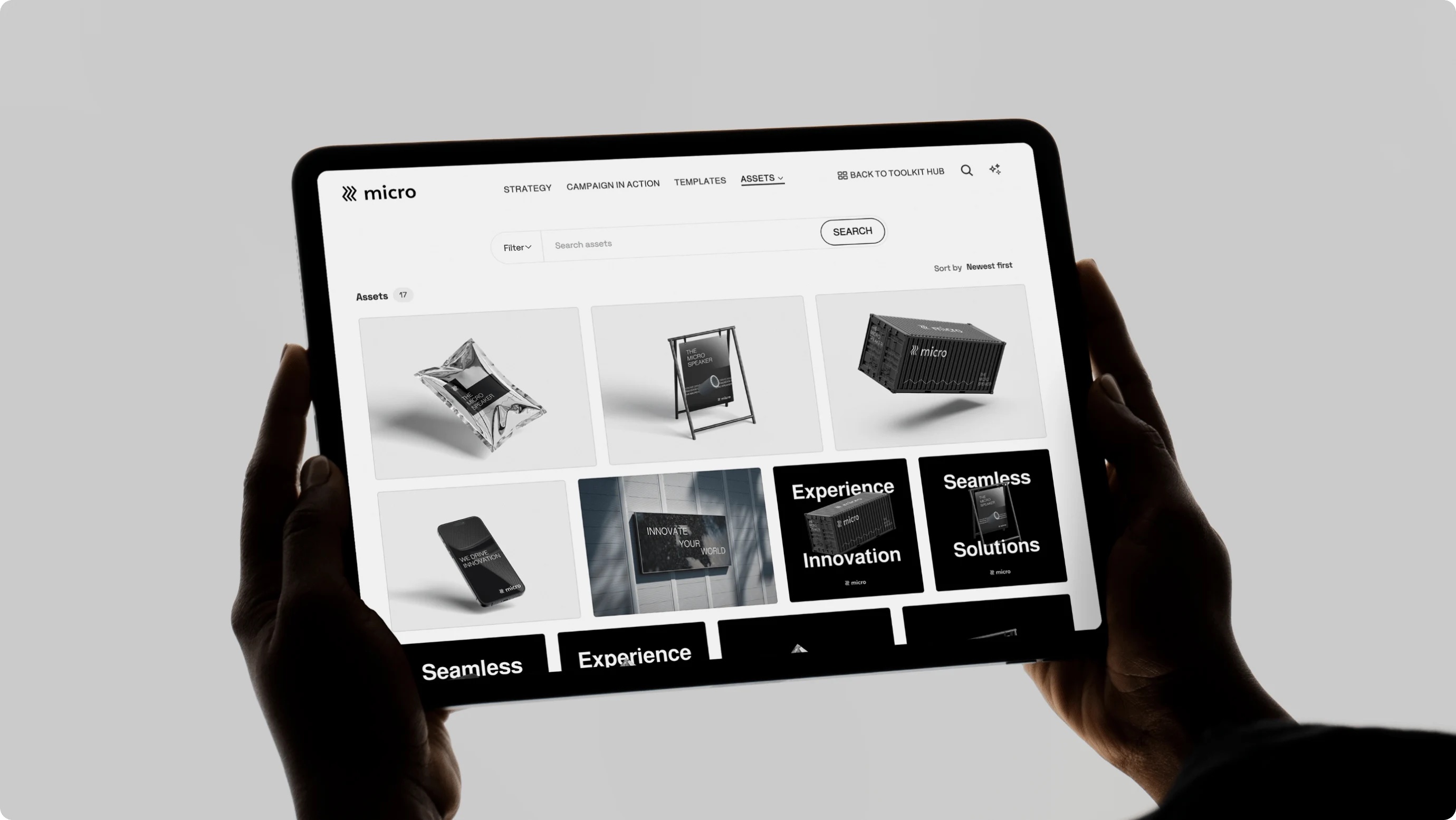 Frontify brand guidelines on an iPad held up by two hands
