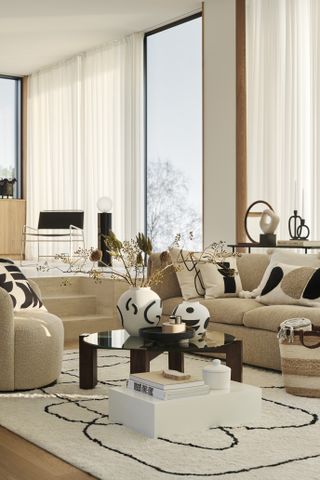 A modern cream living room with coffee table, and geometric accessories including cushions and vases