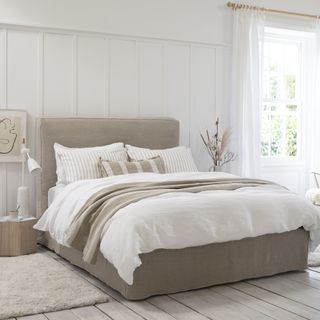 White bedroom with wall panelling and grey bed