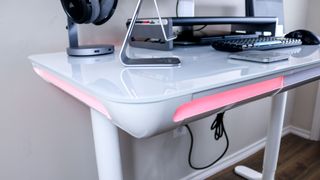 The LiftSync Clear Plus at an angle to show how its integrated RGB lighting wraps around the desk