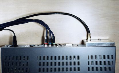 Side view of a metal cable box with cords attached.
