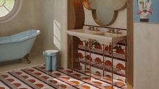 A bathroom with red patterned tiles flowing from the walls to the floor
