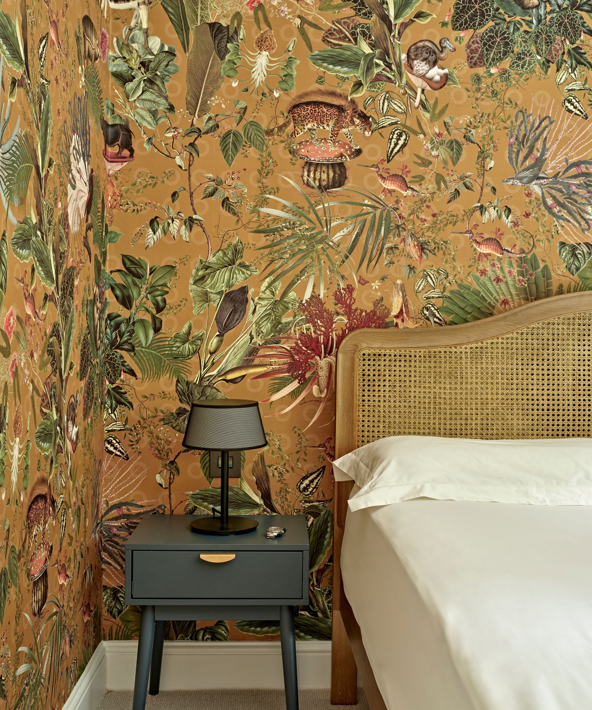 yellow fauna wallpaper in bedroom with rattan bed