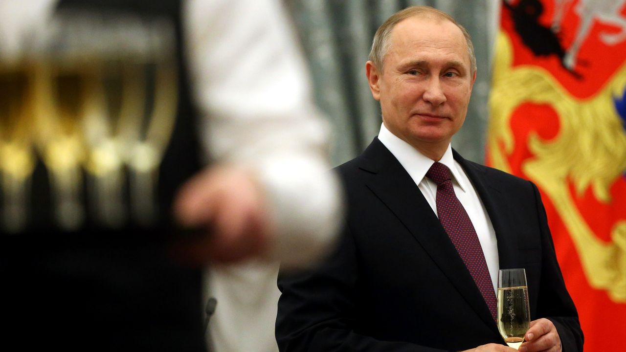 Russian President Vladimir Putin holds a glass of champagne