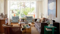 neutral living room with artwork, sofa and armchairs to demonstrate how to combine heirlooms with contemporary style