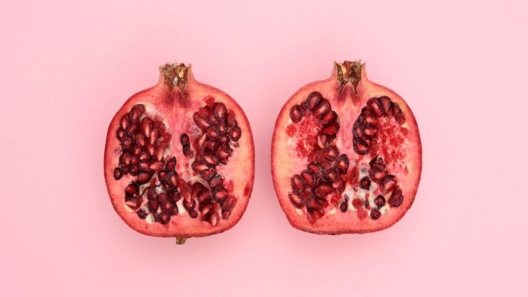 Open pomegranate on pink background