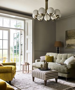 sage green living room with neutral sofa and ceiling light