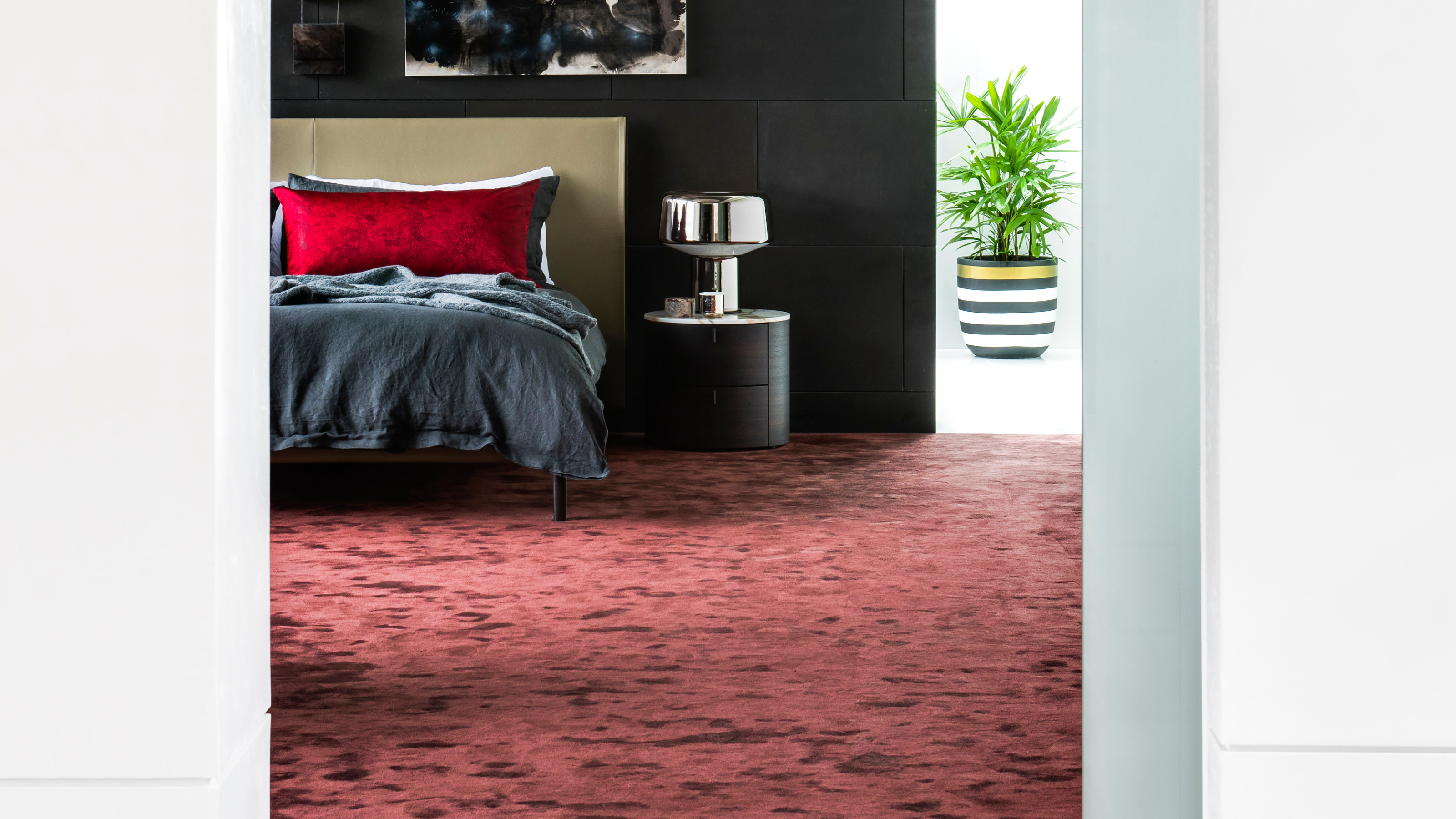 a plush dark red carpet in a modern bedroom shot between two open doors