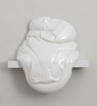 A 3D piece of white artwork, appearing to slide off the shelf it sits on