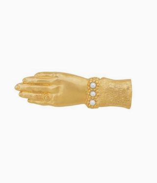 gold brooch hand with pearls on it