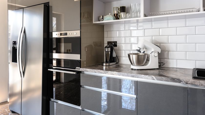 Spacious luxury well designed modern grey, beige and white kitchen, door of electric oven are open