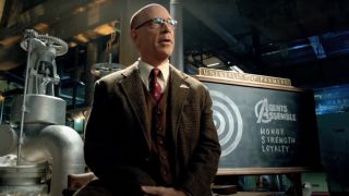 J.K. Simmons stands in the middle of a presentation for Farmers Insurance.