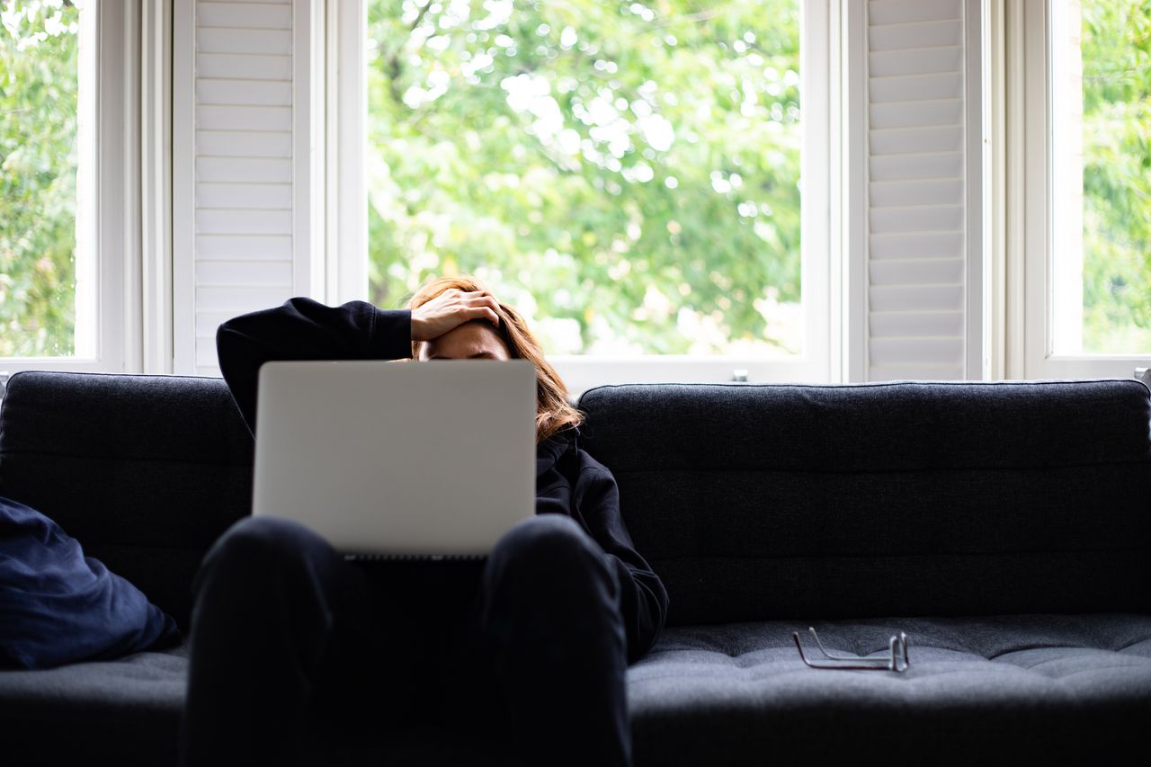 Woman sitting on sofa looking for a job. 