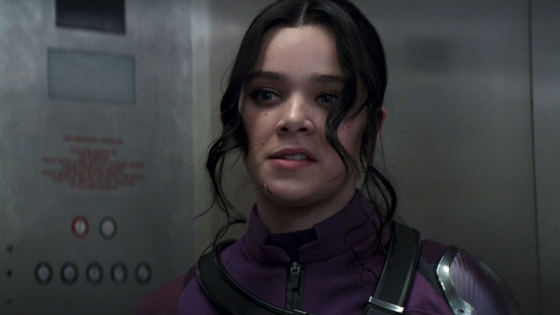 Kate Bishop riding the elevator in her purple suit in Hawkeye.