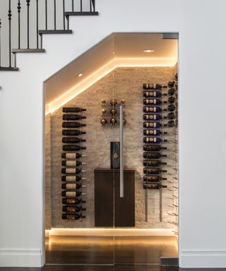 An under stairs idea with a LED-lit wine cellar in modern white staircase